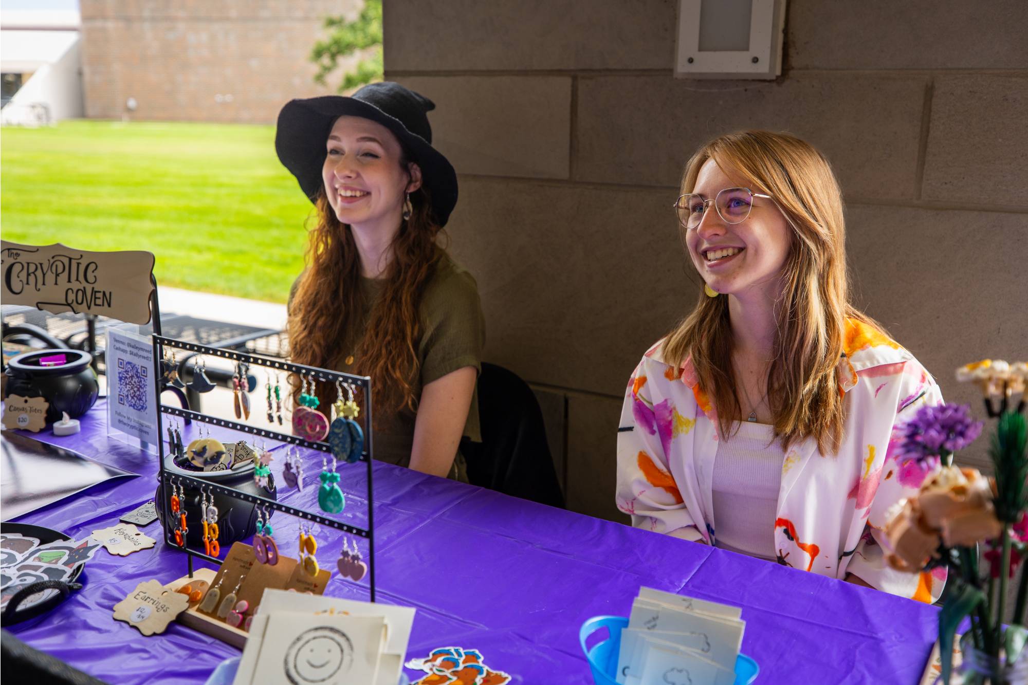 two women sitting at a table for student small business market